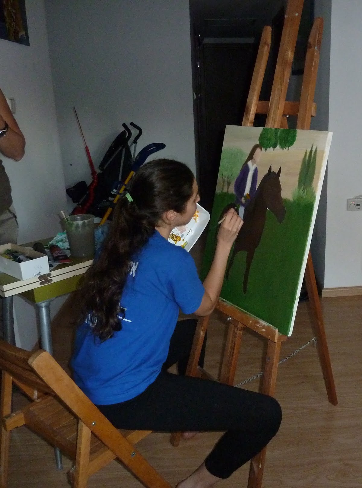 At the easel painting a horse and rider